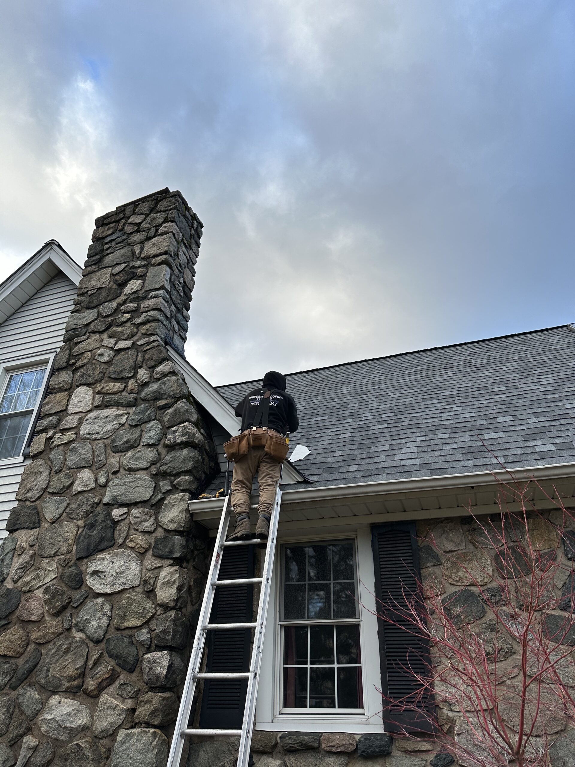 Technician performing roof repair on a residential property in Totowa, NJ​