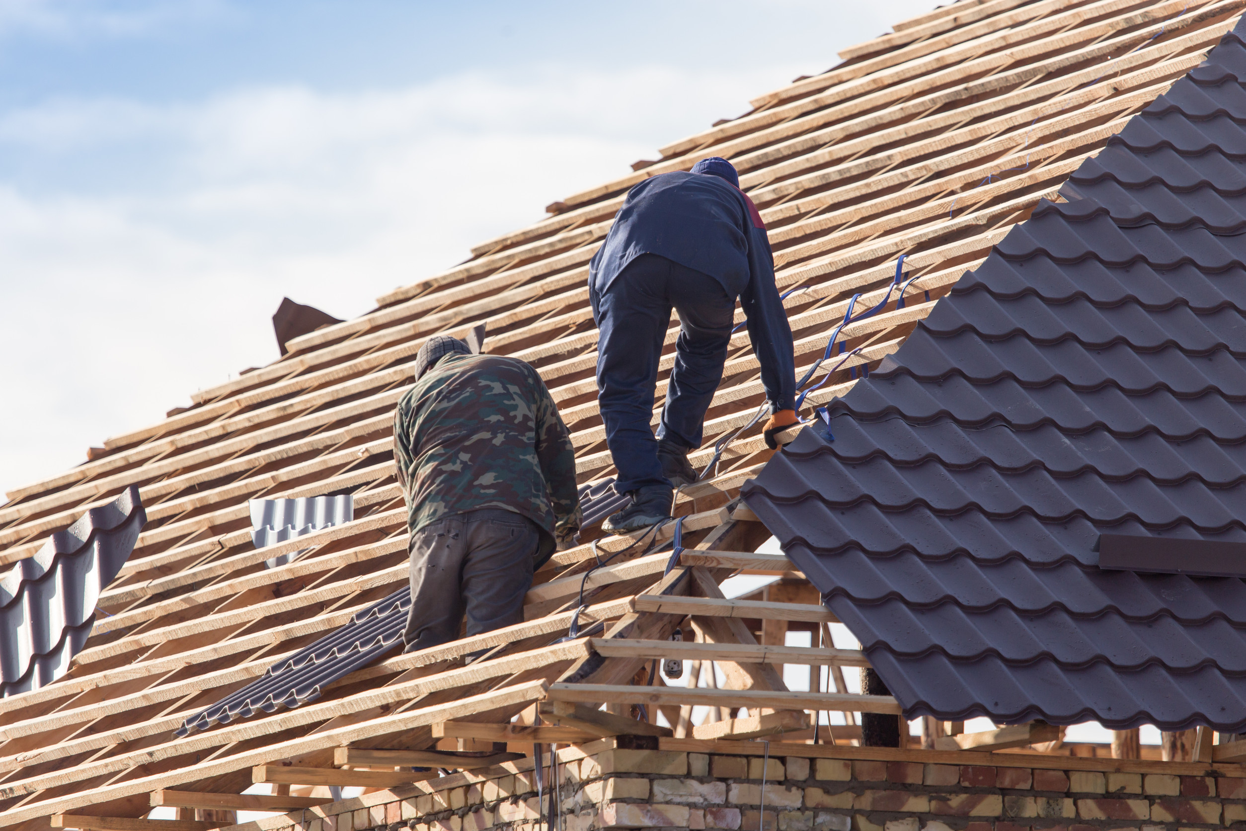 roofing team working on a residential roof in New Jersey with safety gear and tools